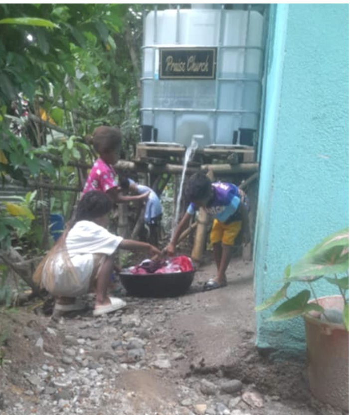 Children washing clothes with clean water at Keith Chapel