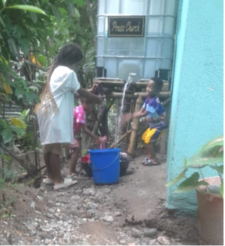 Children using the clean water source at Keith Chapel