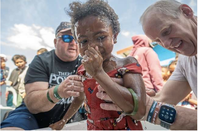 Mission team supporting a child during the dedication